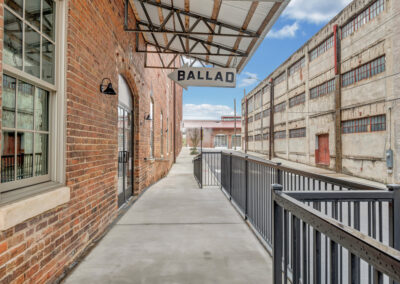 Walkway with railing leading to "Ballad Brewing" sign