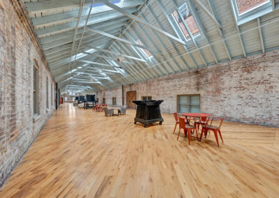 Long common hall space with exposed brick, skylight windows, and hardwood floors