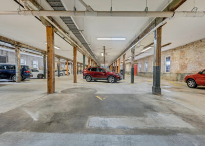 Covered parking garage with historic vertical wood beams and exposed brick walls