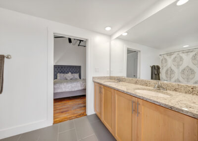 Double vanity with granite countertop off bedroom