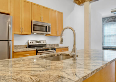 Close up of chrome gooseneck faucet and granite counter top